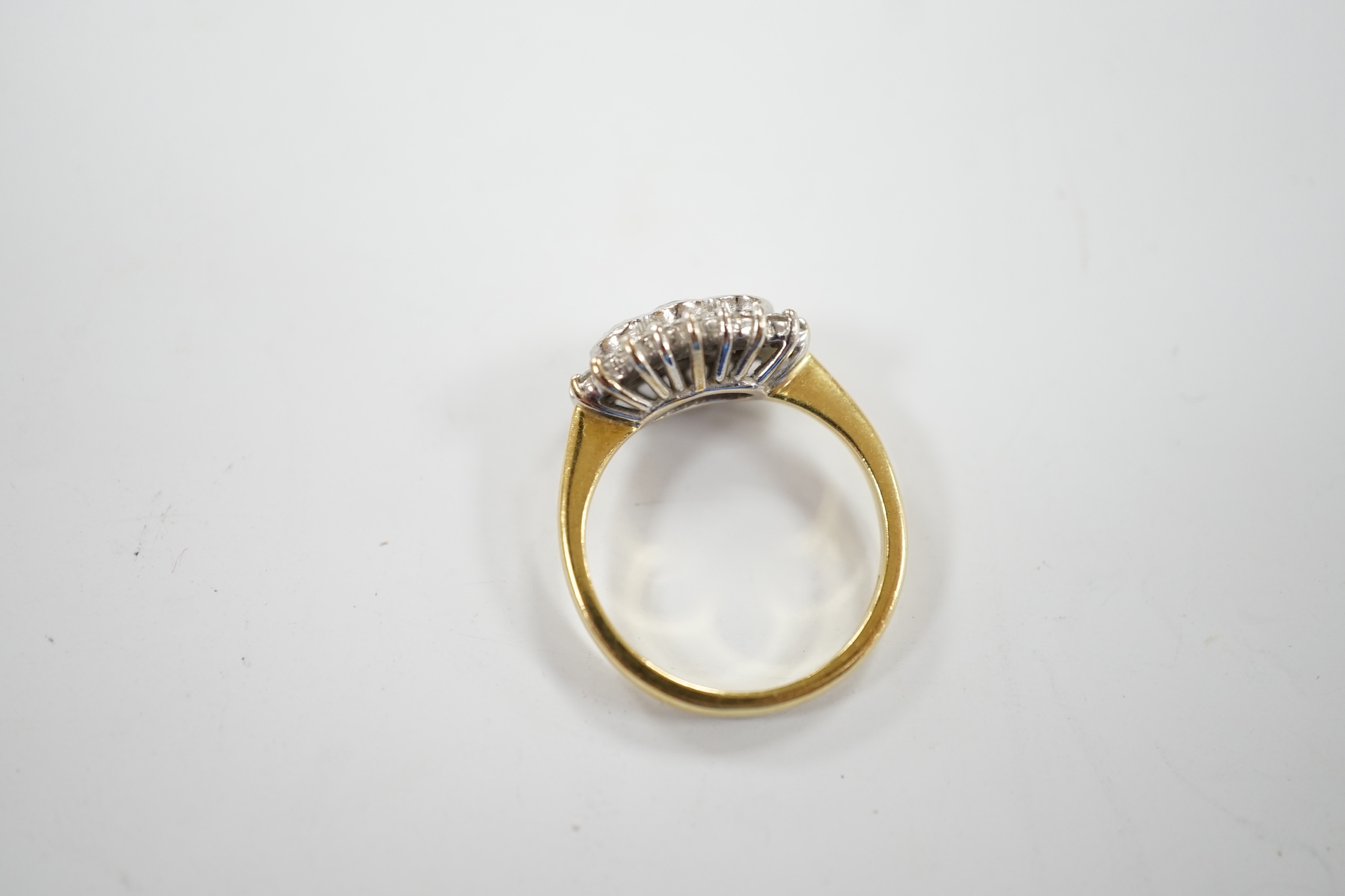 A modern 18ct gold and collet set three stone diamond ring, with diamond chip set border, size J/K, gross weight 4.6 grams.